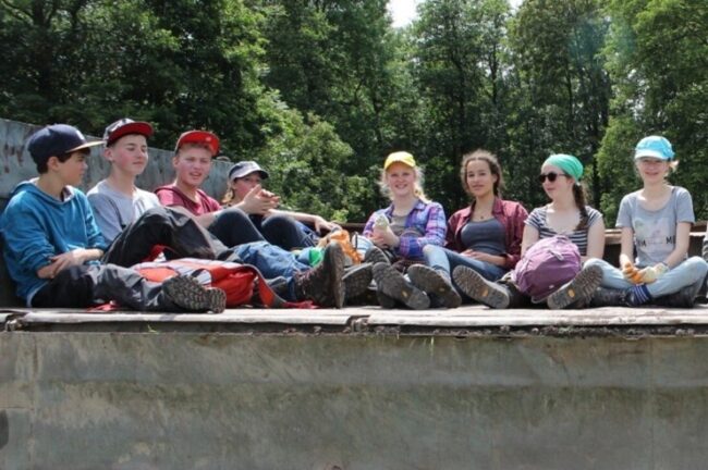Kinder sitzen auf einer Mauer